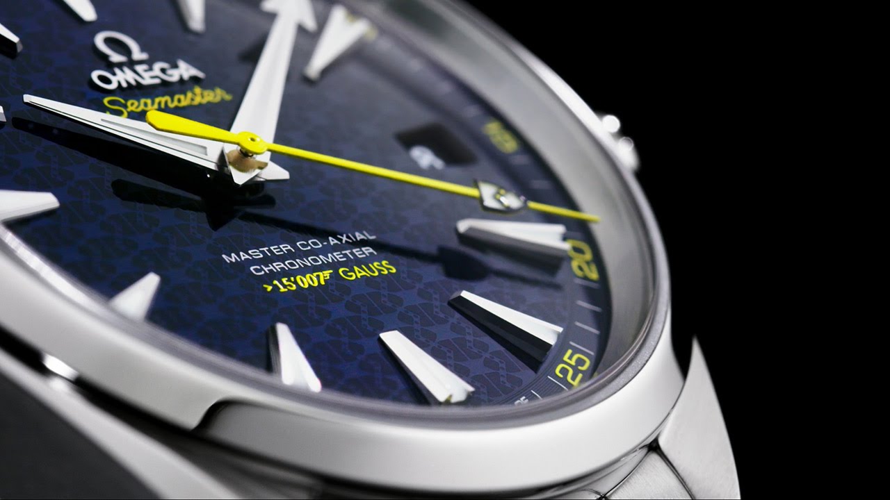 James Bond's iconic coat of arms features patterned on the striking blue dial and at the tip of the bright yellow second hand.