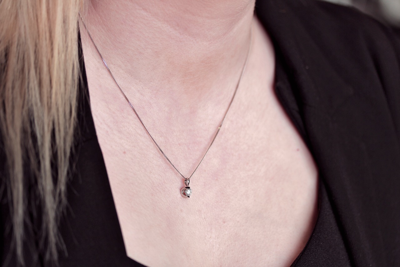 The sparkling pendant sits elegantly on the neckline.