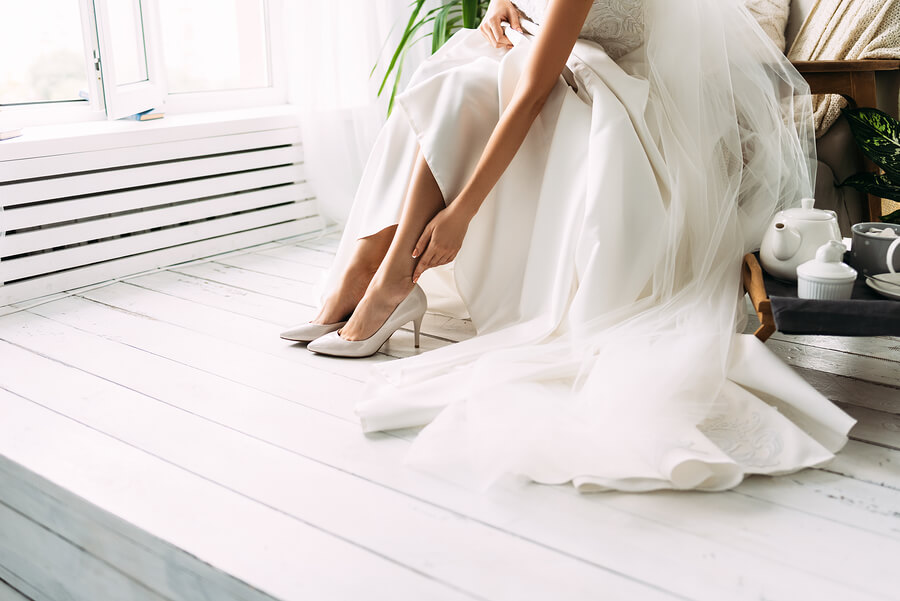 A bride putting her shoes on for her wedding