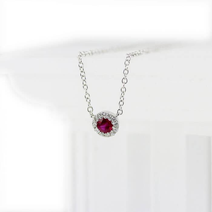 A ruby jewel necklace with diamonds surrounding.