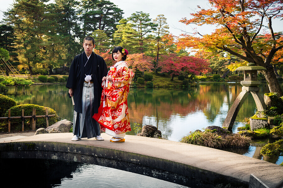 A traditional Japanese bride and groom wearing an iro-uchikake and a montsuki
