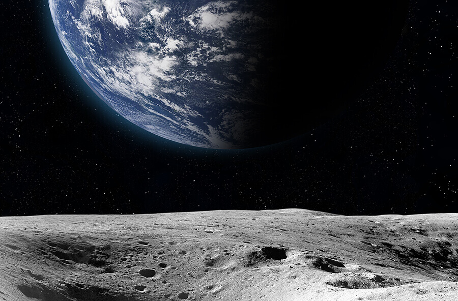 the moon's surface in the foreground and earth in the background