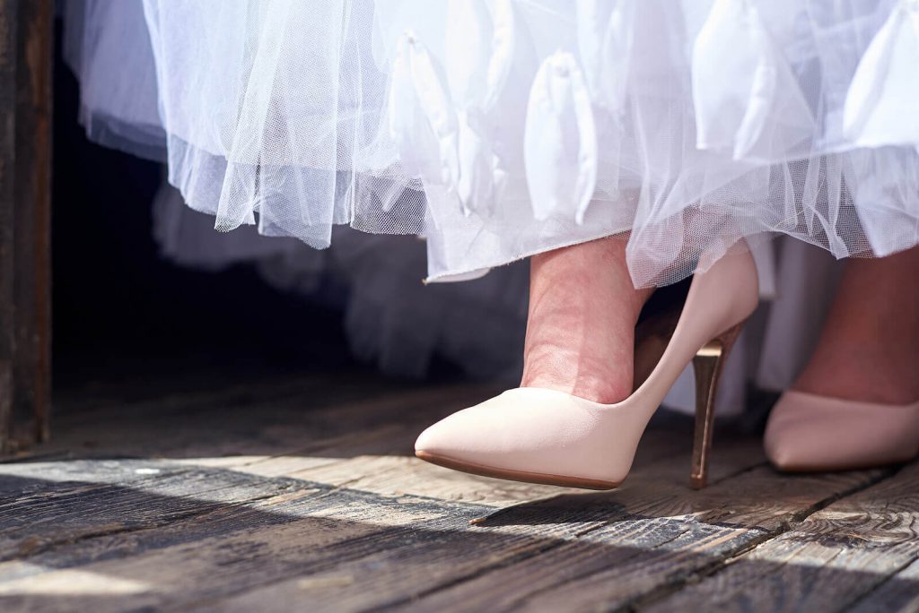 A bride's nude shoe and the bottom of her white dress