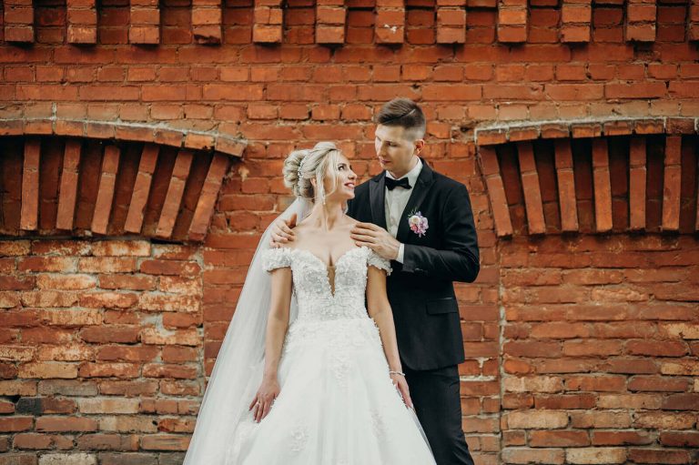 A German bride and groom stood by a brick wall at their wedding. German wedding traditions