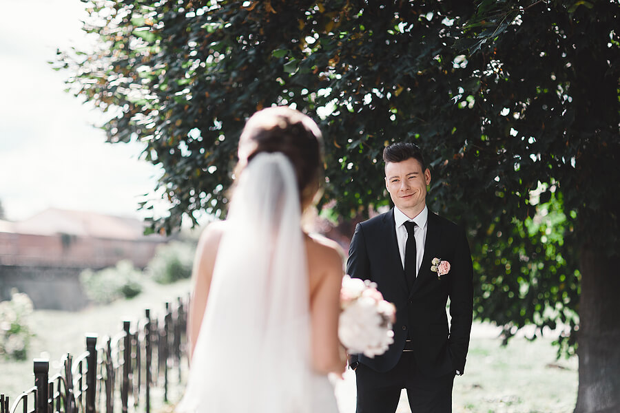 A white bride and groom on their wedding day in a park with trees