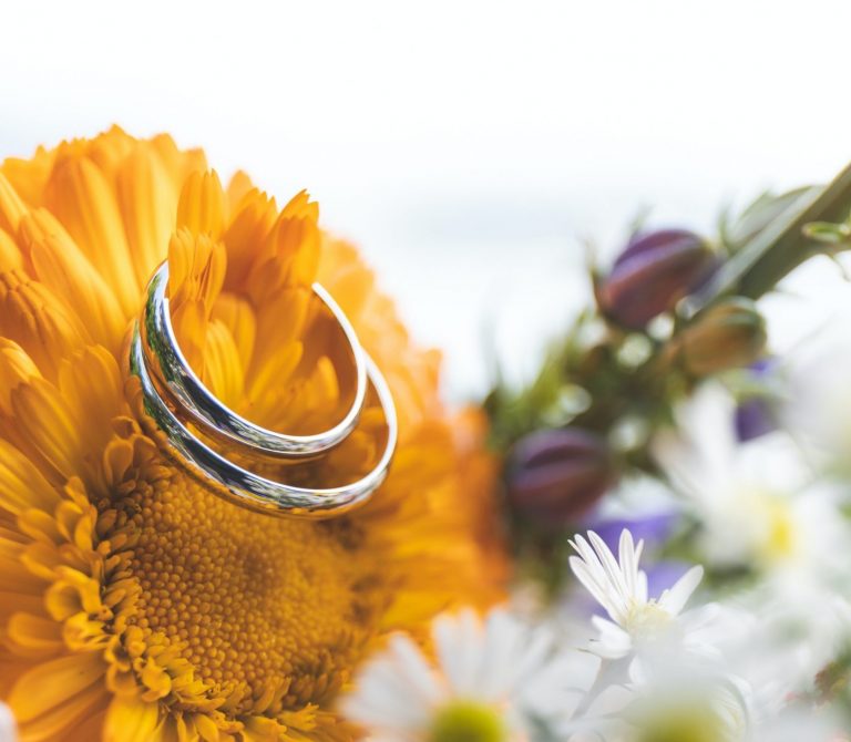Close up of two wedding rings on a bouquet of flowers