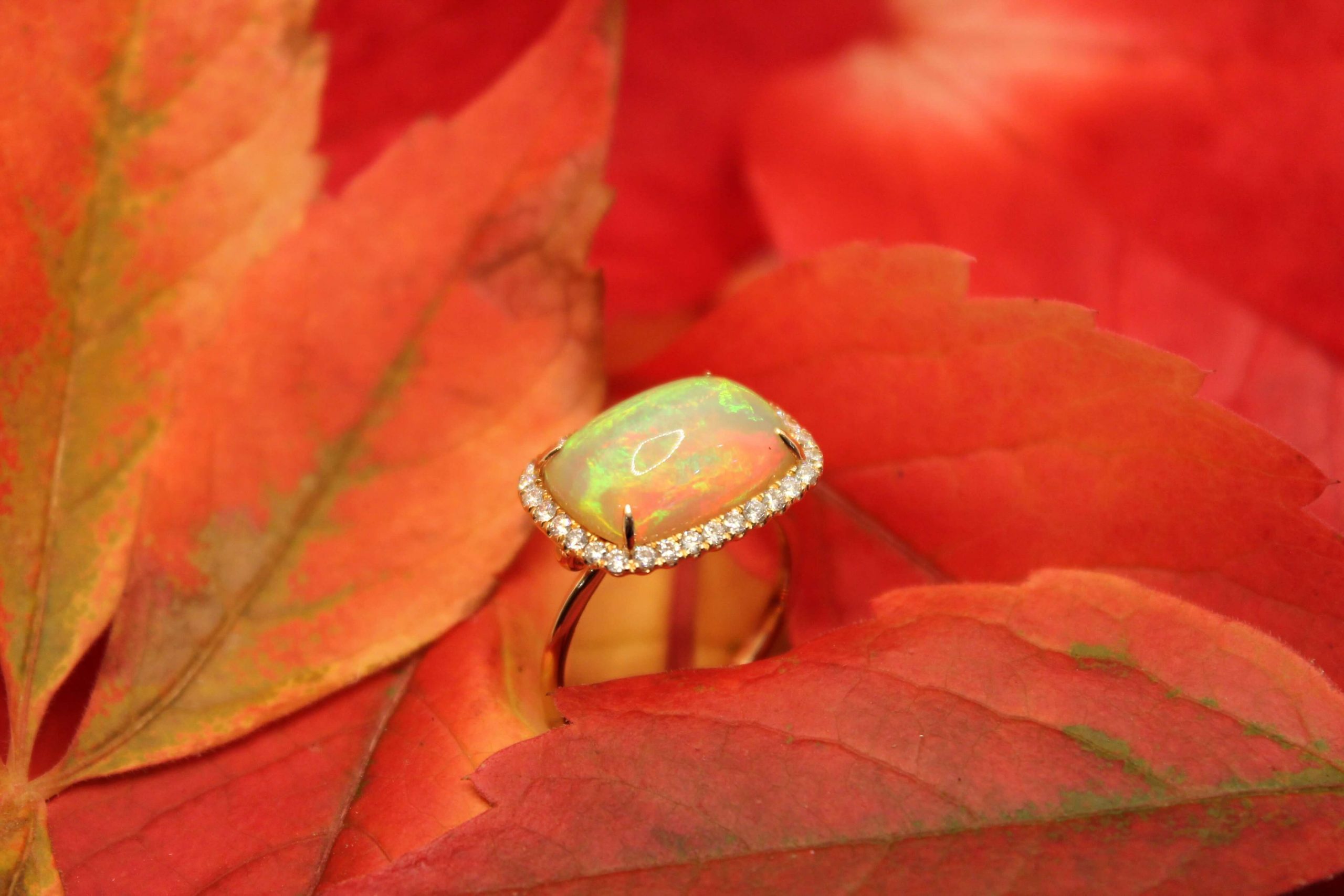 An 18CT ROSE GOLD 4.19CT OPAL AND 0.37CT DIAMOND HALO RING from Robert Gatward Jewellers