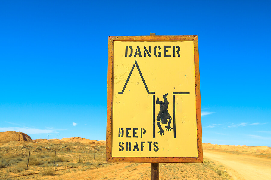 Close up of danger cave deep shafts road sign in Coober Pedy underground town of Australia. Opal mining town in the South Australian outback desert.