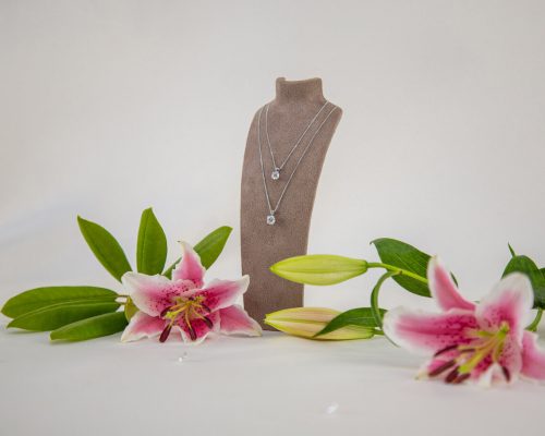 lab grown diamonds. lab grown diamond necklaces on bust with lillies.